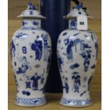 A pair of Chinese blue and white baluster vases and covers, decorated with figures, 37cm