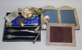 A silver mounted double photograph frame, a silver sauceboat, silver card case, silver vestas etc.