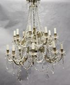 An 18th century style gilt brass and glass sixteen light chandelier, hung with lustre and tear