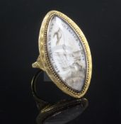 An early 19th century gold and ivory mourning ring, of navette shape, the panel decorated with