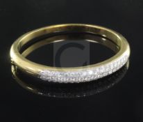 An 18ct gold and diamond hinged bangle, set with three rows of graduated round brilliant cut stones,