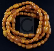 A long single strand amber necklace, with oval and barrel shaped beads, gross weight 192 grams,