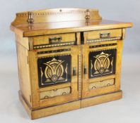 A Victorian Aesthetic Movement marquetry inlaid oak side cabinet, with two frieze drawers and two