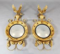 A pair of Regency style giltwood convex girandoles, with carved eagle surmounts, W.1ft 8in. H.3ft