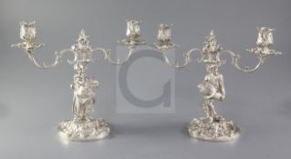 A pair of 1970's cast silver two branch, two light candelabra by Mappin & Webb, with figural stem