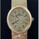 A lady's 18ct gold Baume and Mercier manual wind wrist watch, with textured oval dial and baton