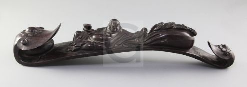 A Chinese hardwood ruyi sceptre, carved in high relief and open work with the recumbent figure of