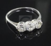 A mid 20th century white gold and three stone diamond ring, size N.