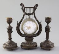 An early 20th century French patinated bronze garniture, the timepiece in lyre case, with 2.25