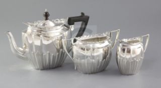 A late Victorian silver three piece tea set by James Dixon & Sons, of oval form, with demi reeded