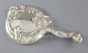 An early 20th century Art Nouveau sterling silver mounted hand mirror, embossed with stylised lady