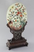 A Chinese hardstone and rosewood table screen, early 20th century, the oval panel overlaid in