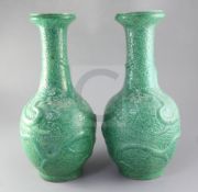 A pair of Chinese green glazed 'dragon' vases, late 19th/early 20th century, each moulded with