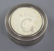 A late 19th/early 20th French silver and ivory circular snuff box, the lid carved in relief with "