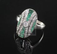 An Art Deco style 18ct white gold, emerald and diamond oval dress ring, set with round cut