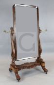 A Regency mahogany cheval mirror, with arched plate and brass candle sconces, W.2ft 7in. H.5ft 4in.