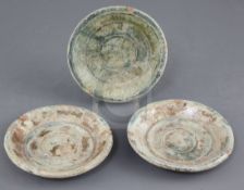 A set of three Chinese green glaze pottery dishes, Han dynasty, each with mineral iridescence,