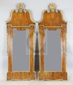 A pair of early 18th century style parcel gilt walnut wall mirrors, with scallop and flower swag