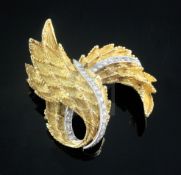 An early 1970's textured 18ct gold and diamond set scrolling laurel leaf brooch, 47mm.