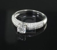 A modern claw set single stone diamond ring with diamond encrusted shoulders, size O.