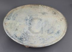 A Chinese green glazed pottery circular tray, Han dynasty, mineral iridescence to the glaze, on