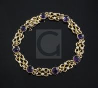 An Edwardian 15ct gold, amethyst and seed pearl bracelet, with shaped links and set with eight round