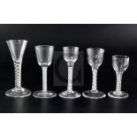 Five 18th century drinking glasses, four with opaque twist stems, one engraved with a Jacobite style