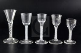 Five 18th century drinking glasses, four with opaque twist stems, one engraved with a Jacobite style