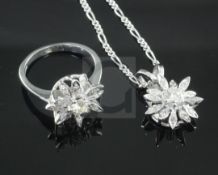 An 18ct white gold and diamond cluster ring in the form of a flowerhead and a matching pendant, 18ct