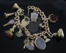 An early 20th century 9ct gold charm bracelet, with heart shaped padlock clasp and hung with