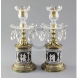 A pair of early 19th century ormolu mounted black jasperware lustre candlesticks, with cut glass