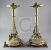 A pair of gothic brass candlesticks, each with three applied angels holding a quatrefoil, raised