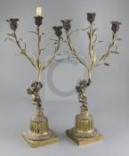 A pair of 19th century French bronze candelabra, modelled with cherubs holding aloft lilies, 23in.