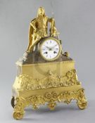 A French Régence gilt and patinated ormolu mantel clock, surmounted by the figure of a seated