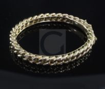 An early 20th century 15ct gold curb link hinged bangle, 20 grams.