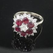 A 1970's 18ct white gold, ruby and diamond cluster ring, of flowerhead design and set with six round