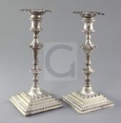 A pair of early George III cast silver candlesticks by Ebenezer Coker, with tapered, knopped stems