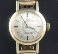 A lady's 9ct gold Omega manual wind wrist watch, on a gold plated bracelet.