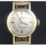 A lady's 9ct gold Omega manual wind wrist watch, on a gold plated bracelet.