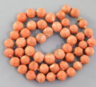 A Chinese coral bead necklace, late 19th / early 20th century, each graduated bead carved in