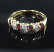 An 18ct ruby and diamond half hoop dress ring, size O.From the estate of the late Sheila