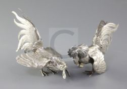 A pair of early 20th century German 800 standard silver model fighting cocks, tallest 12cm, 12 oz.