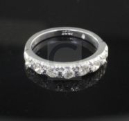 A 20th century 18ct white gold and eight stone diamond half hoop ring, size N.