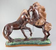 R. Prunet. A tin glazed terracotta group of two mustangs, signed, width 22in. height 19in.