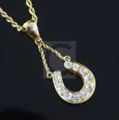 A yellow metal diamond-set 'horseshoe' pendant on 9ct gold chain, pendant 21mm.