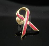 An 18ct gold and red enamel Aids Awareness ribbon brooch, 22mm.From the estate of the late Sheila