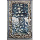 An early 17th century Brussels verdure tapestry, depicting a tree in a landscape within flower and