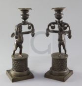 A pair of early 19th century bronze candlesticks, with cherub stems and diapered bases, the