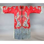 A Chinese embroidered silk 'dragon' robe, woven in metal thread and long threads on a red satin