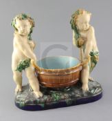 A Victorian Minton majolica group of two putti carrying a wooden tub, impressed marks, width 28cm